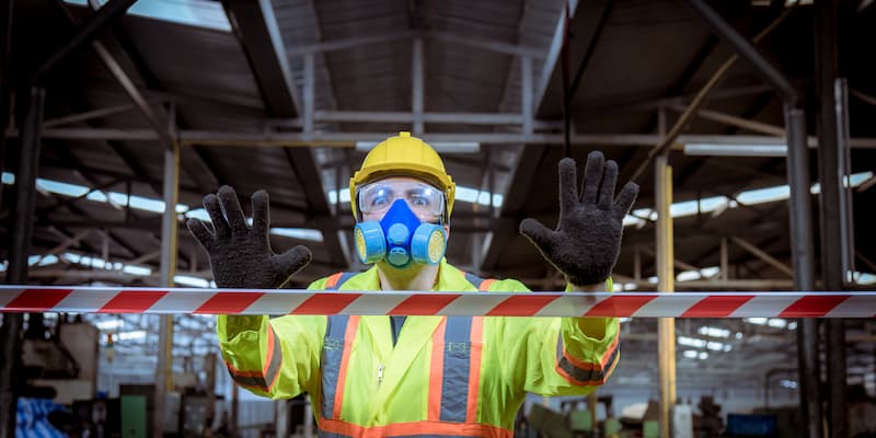 Construction worker wearing 6-point PPE holding his hands up, symbolising stop